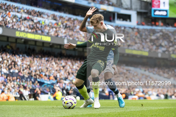 Keane Lewis-Potter #23 of Brentford F.C. is tackled by Savinho #26 of Manchester City F.C. during the Premier League match between Mancheste...