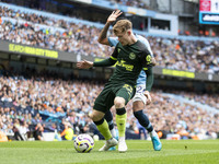 Keane Lewis-Potter #23 of Brentford F.C. is tackled by Savinho #26 of Manchester City F.C. during the Premier League match between Mancheste...