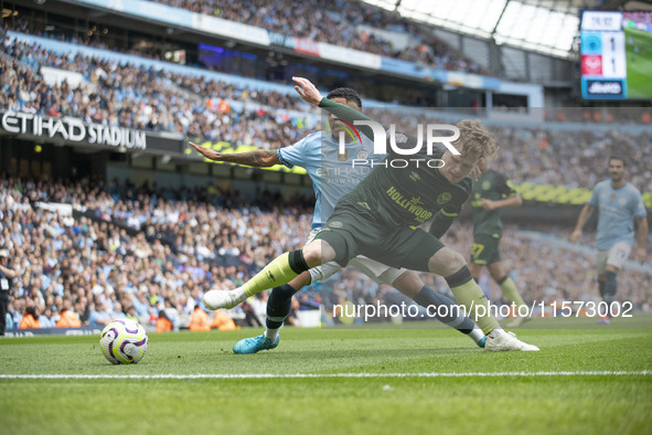 Keane Lewis-Potter #23 of Brentford F.C. is tackled by Savinho #26 of Manchester City F.C. during the Premier League match between Mancheste...