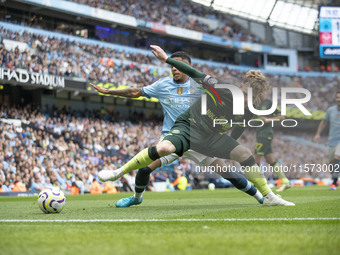 Keane Lewis-Potter #23 of Brentford F.C. is tackled by Savinho #26 of Manchester City F.C. during the Premier League match between Mancheste...