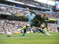 Keane Lewis-Potter #23 of Brentford F.C. is tackled by Savinho #26 of Manchester City F.C. during the Premier League match between Mancheste...