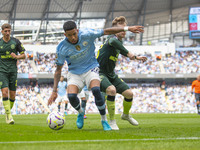 Savinho #26 of Manchester City F.C. is tackled by Keane Lewis-Potter #23 of Brentford F.C. during the Premier League match between Mancheste...