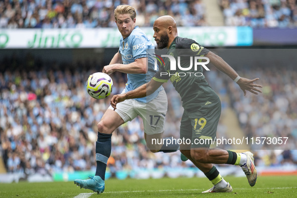 Bryan Mbeumo #19 of Brentford F.C. is tackled by Kevin De Bruyne #17 of Manchester City F.C. during the Premier League match between Manches...