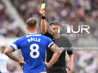 Referee Matthew Donohue shows a yellow card to Joe Ralls of Cardiff City during the Sky Bet Championship match between Derby County and Card...