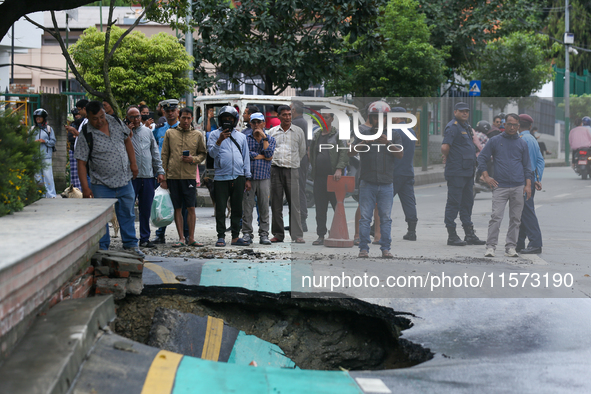 A section of road caves in after a water supply pipe malfunctions in Lalitpur, Nepal, on September 14, 2024. The incidents of roads caving i...