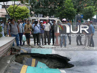 A section of road caves in after a water supply pipe malfunctions in Lalitpur, Nepal, on September 14, 2024. The incidents of roads caving i...