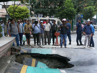 A section of road caves in after a water supply pipe malfunctions in Lalitpur, Nepal, on September 14, 2024. The incidents of roads caving i...