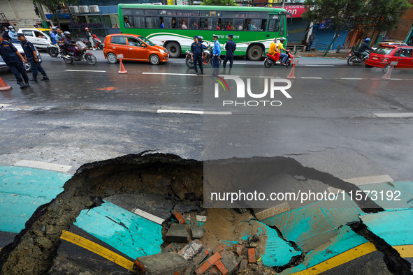 A section of road caves in after a water supply pipe malfunctions in Lalitpur, Nepal, on September 14, 2024. The incidents of roads caving i...