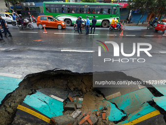 A section of road caves in after a water supply pipe malfunctions in Lalitpur, Nepal, on September 14, 2024. The incidents of roads caving i...