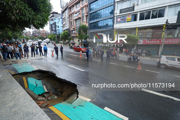 A section of road caves in after a water supply pipe malfunctions in Lalitpur, Nepal, on September 14, 2024. The incidents of roads caving i...