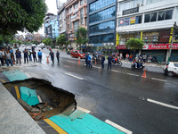 A section of road caves in after a water supply pipe malfunctions in Lalitpur, Nepal, on September 14, 2024. The incidents of roads caving i...