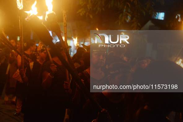 Women and citizens hold burning lanterns as they take part in a protest march to condemn the rape and murder of a young medic in Siliguri, I...