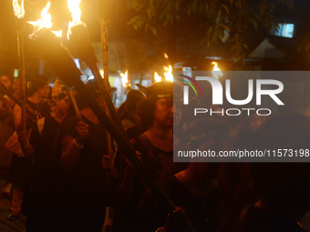 Women and citizens hold burning lanterns as they take part in a protest march to condemn the rape and murder of a young medic in Siliguri, I...