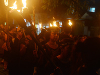 Women and citizens hold burning lanterns as they take part in a protest march to condemn the rape and murder of a young medic in Siliguri, I...