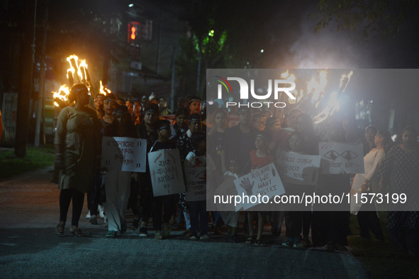 Children hold placards as women and citizens hold burning lanterns as they take part in a protest march to condemn the rape and murder of a...