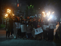 Children hold placards as women and citizens hold burning lanterns as they take part in a protest march to condemn the rape and murder of a...