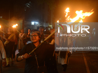 Women and citizens hold burning lanterns as they take part in a protest march to condemn the rape and murder of a young medic in Siliguri, I...