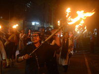 Women and citizens hold burning lanterns as they take part in a protest march to condemn the rape and murder of a young medic in Siliguri, I...