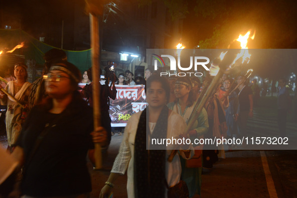 Women and citizens hold burning lanterns as they take part in a protest march to condemn the rape and murder of a young medic in Siliguri, I...