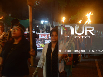 Women and citizens hold burning lanterns as they take part in a protest march to condemn the rape and murder of a young medic in Siliguri, I...