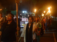 Women and citizens hold burning lanterns as they take part in a protest march to condemn the rape and murder of a young medic in Siliguri, I...