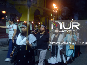 Women and citizens hold burning lanterns as they take part in a protest march to condemn the rape and murder of a young medic in Siliguri, I...