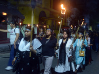 Women and citizens hold burning lanterns as they take part in a protest march to condemn the rape and murder of a young medic in Siliguri, I...