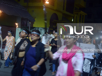 Women and citizens hold burning lanterns as they take part in a protest march to condemn the rape and murder of a young medic in Siliguri, I...