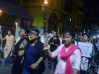 Women and citizens hold burning lanterns as they take part in a protest march to condemn the rape and murder of a young medic in Siliguri, I...