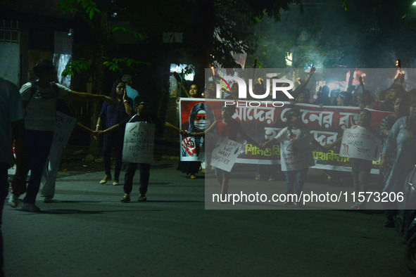 Children hold placards as women and citizens hold burning lanterns as they take part in a protest march to condemn the rape and murder of a...