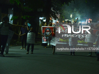 Children hold placards as women and citizens hold burning lanterns as they take part in a protest march to condemn the rape and murder of a...