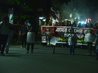 Children hold placards as women and citizens hold burning lanterns as they take part in a protest march to condemn the rape and murder of a...