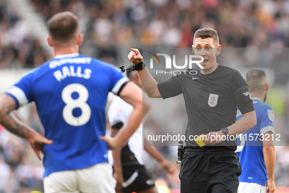 Referee Matthew Donohue shows a yellow card to Joe Ralls of Cardiff City during the Sky Bet Championship match between Derby County and Card...