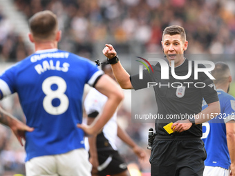 Referee Matthew Donohue shows a yellow card to Joe Ralls of Cardiff City during the Sky Bet Championship match between Derby County and Card...