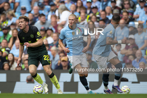 Nathan Collins #22 of Brentford F.C. passes Erling Haaland #9 of Manchester City F.C. during the Premier League match between Manchester Cit...