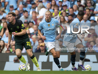 Nathan Collins #22 of Brentford F.C. passes Erling Haaland #9 of Manchester City F.C. during the Premier League match between Manchester Cit...