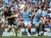 Nathan Collins #22 of Brentford F.C. passes Erling Haaland #9 of Manchester City F.C. during the Premier League match between Manchester Cit...