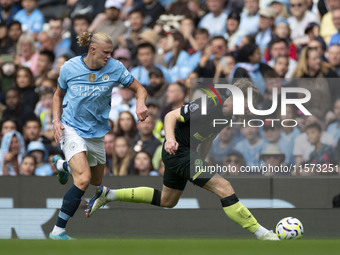 Nathan Collins #22 of Brentford F.C. is tackled by Erling Haaland #9 of Manchester City F.C. during the Premier League match between Manches...