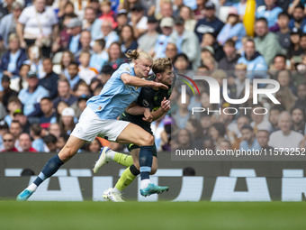 Nathan Collins #22 of Brentford F.C. is tackled by Erling Haaland #9 of Manchester City F.C. during the Premier League match between Manches...