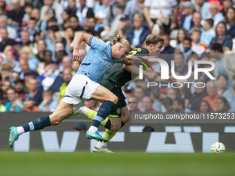 Nathan Collins #22 of Brentford F.C. is tackled by Erling Haaland #9 of Manchester City F.C. during the Premier League match between Manches...