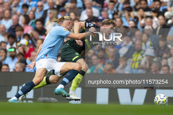 Nathan Collins #22 of Brentford F.C. is tackled by Erling Haaland #9 of Manchester City F.C. during the Premier League match between Manches...