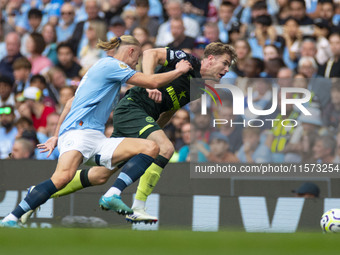 Nathan Collins #22 of Brentford F.C. is tackled by Erling Haaland #9 of Manchester City F.C. during the Premier League match between Manches...