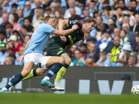 Nathan Collins #22 of Brentford F.C. is tackled by Erling Haaland #9 of Manchester City F.C. during the Premier League match between Manches...