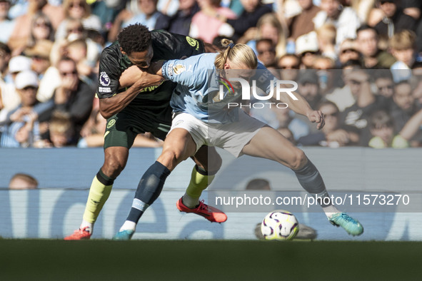 Erling Haaland #9 of Manchester City F.C. is tackled by the opponent during the Premier League match between Manchester City and Brentford a...