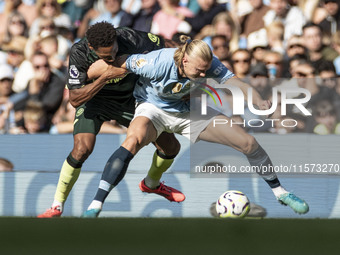 Erling Haaland #9 of Manchester City F.C. is tackled by the opponent during the Premier League match between Manchester City and Brentford a...