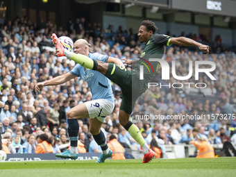 Erling Haaland #9 of Manchester City F.C. tackles Ethan Pinnock #5 of Brentford F.C. during the Premier League match between Manchester City...