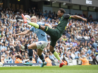 Erling Haaland #9 of Manchester City F.C. tackles Ethan Pinnock #5 of Brentford F.C. during the Premier League match between Manchester City...