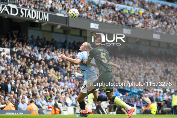 Erling Haaland #9 of Manchester City F.C. tackles Ethan Pinnock #5 of Brentford F.C. during the Premier League match between Manchester City...