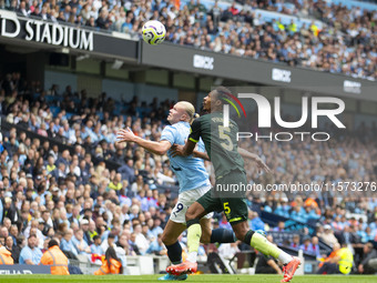 Erling Haaland #9 of Manchester City F.C. tackles Ethan Pinnock #5 of Brentford F.C. during the Premier League match between Manchester City...