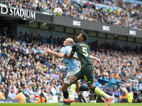 Erling Haaland #9 of Manchester City F.C. tackles Ethan Pinnock #5 of Brentford F.C. during the Premier League match between Manchester City...